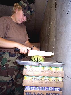  Private First Class Barbie Huscussun, of Dover, Ohio, a member 
of the 1485th Transportation Company, Canton, Ohio, prepares watermelon for the evening meal.